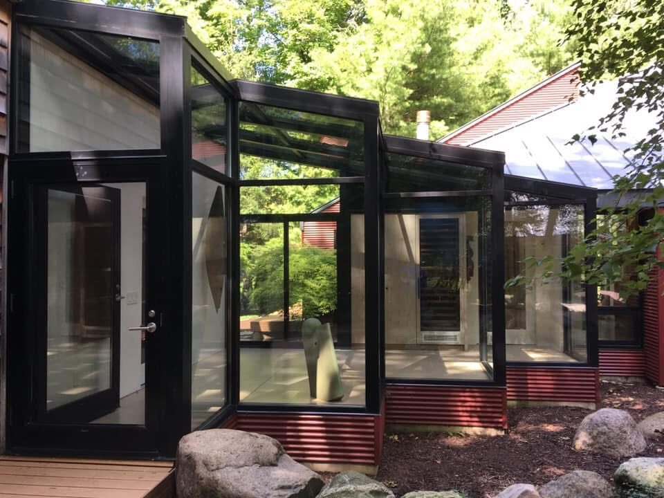 Modern glass-walled walkway with black steel framing